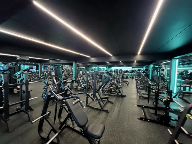 Strength-training machines across the mirrored gym floor at Huracan Fitness.