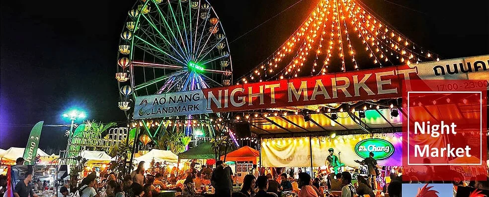 Crowds beneath the illuminated Ao Nang Landmark Night Market entrance at night.